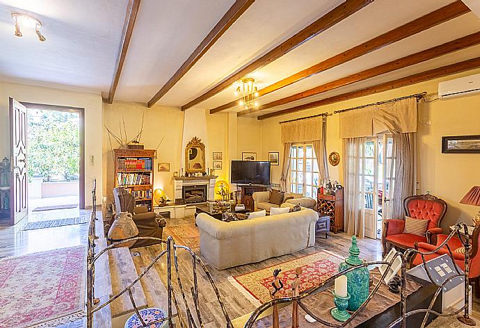 Open-plan living room with sofas, dining areas, kitchen, ornamental fireplace, WiFi internet, satellite TV, DVD player, A/C, and pool terrace access . - Villa Durrell . (Fotogalerie) }}