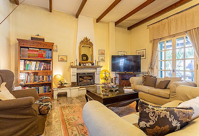 Open-plan living room with sofas, dining areas, kitchen, ornamental fireplace, WiFi internet, satellite TV, DVD player, A/C, and pool terrace access . - Villa Durrell . (Fotogalerie) }}