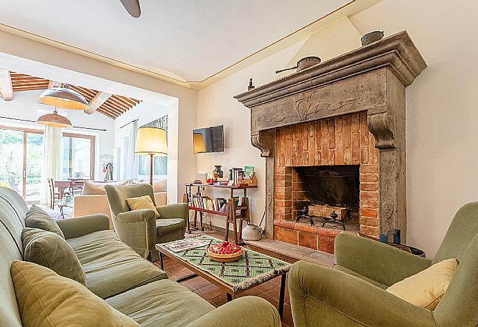 Living room on ground floor of main building with sofas, dining area, ornamental fireplaces, A/C, WiFi internet, satellite TVs, DVD player, and garden access  . - Villa Casale Silvia . (Fotogalerie) }}