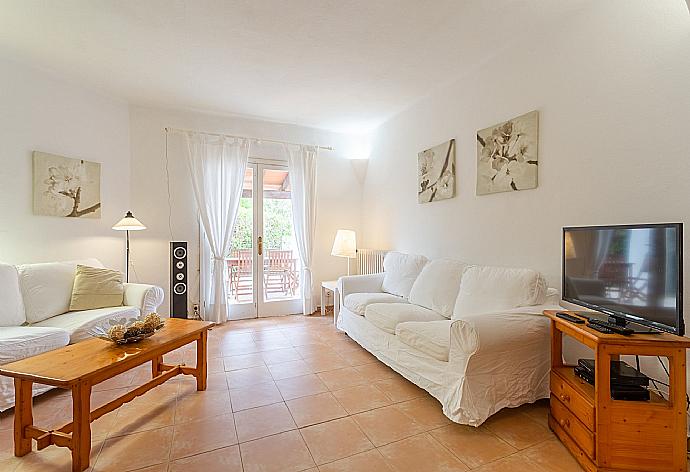 Open-plan living room with sofas, dining area, kitchen, ornamental fireplace, WiFi internet, satellite TV, DVD player, and terrace access . - Villa Corb Mari . (Fotogalerie) }}