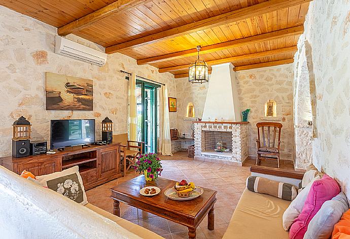 Open-plan living room with sofas, dining area, kitchen, ornamental fireplace, A/C, WiFi internet, satellite TV, and terrace access . - Villa Diony . (Galerie de photos) }}
