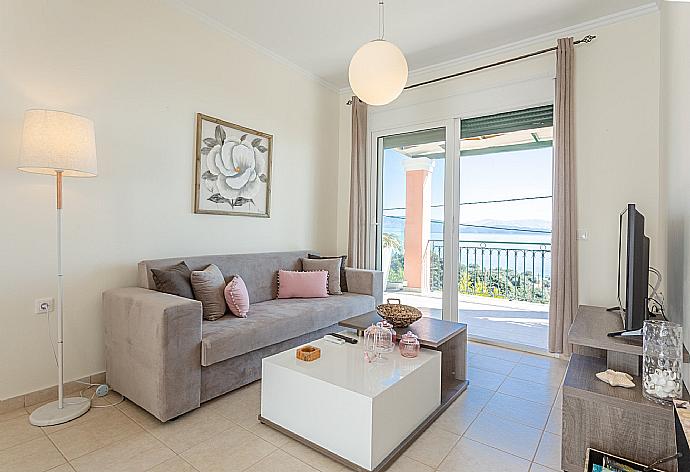 Open-plan living room with sofa, dining area, kitchen, A/C, WiFi internet, satellite TV, and pool terrace with access with panoramic sea views . - Akti Barbati Villa Tria . (Photo Gallery) }}