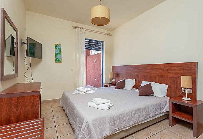 Double bedroom with A/C, TV, and pool terrace access . - Villa Pelagos . (Photo Gallery) }}