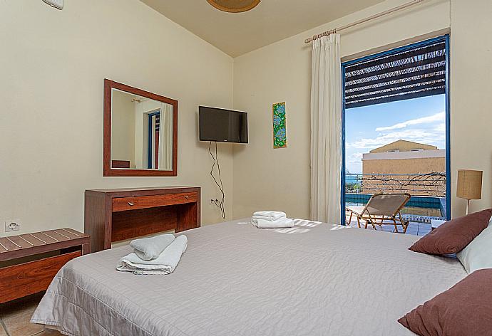 Double bedroom with A/C, TV, and pool terrace access . - Villa Pelagos . (Photo Gallery) }}