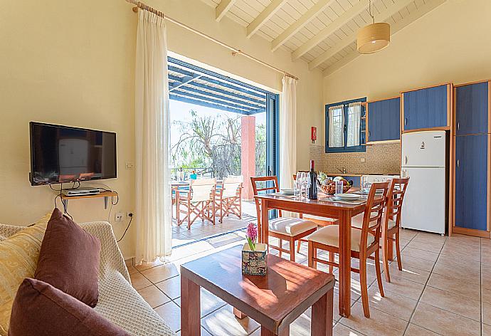 Open-plan living room with sofa, dining area, kitchen, A/C, WiFi internet, satellite TV, and pool terrace access . - Villa Thalassaki . (Galería de imágenes) }}