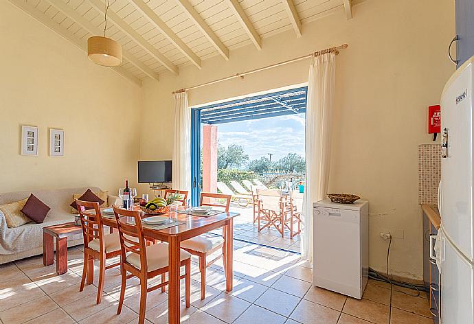 Open-plan living room with sofa, dining area, kitchen, A/C, WiFi internet, satellite TV, and pool terrace access . - Villa Thalassaki . (Galería de imágenes) }}