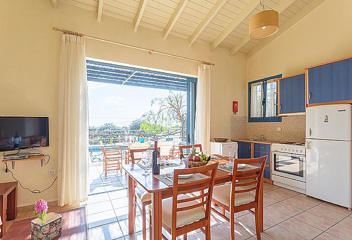 Open-plan living room with sofa, dining area, equipped kitchen, A/C, WiFi internet, satellite TV, and pool terrace access . - Villa Thalassaki . (Galleria fotografica) }}