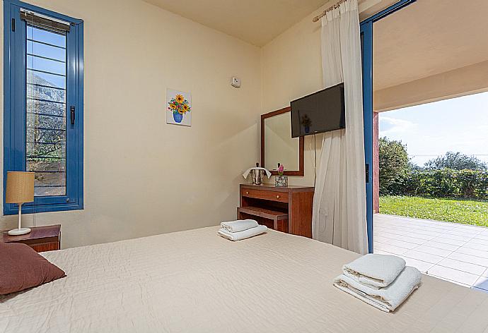 Double bedroom with A/C, TV, and terrace access . - Villa Thalassaki . (Photo Gallery) }}
