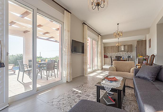 Open-plan living room with sofas, dining area, kitchen, A/C, WiFi internet, satellite TV, and terrace access . - Vatsa Beach Villa . (Fotogalerie) }}