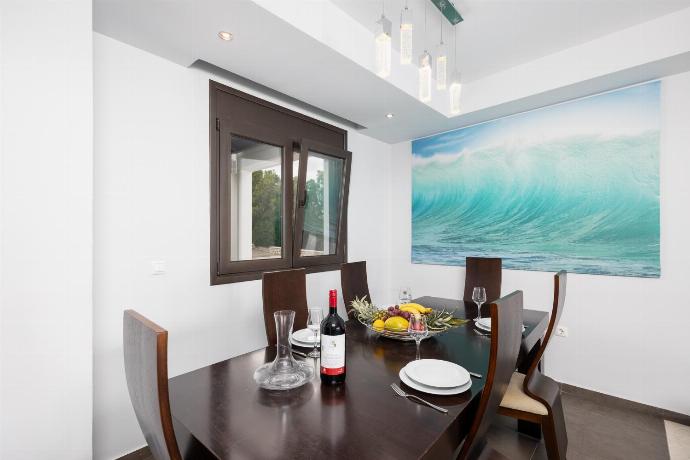 Open-plan living room with sofas, dining area, kitchen, ornamental fireplace, A/C, WiFi internet, satellite TV, and sea views . - Villa Lahania . (Photo Gallery) }}