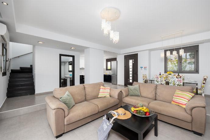 Open-plan living room with sofas, dining area, kitchen, ornamental fireplace, A/C, WiFi internet, satellite TV, and sea views . - Villa Metis . (Photo Gallery) }}