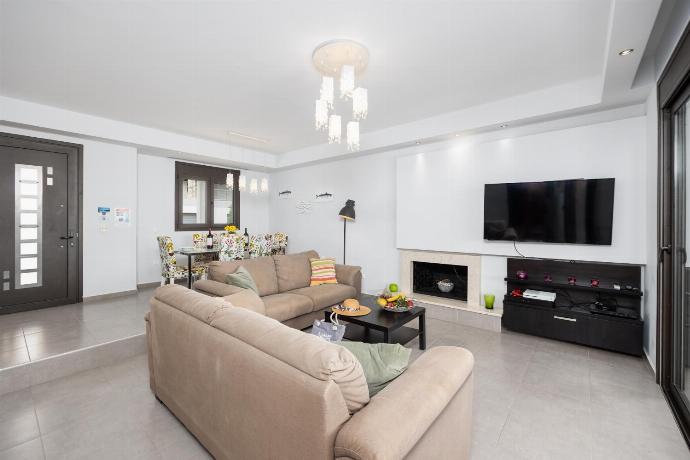 Open-plan living room with sofas, dining area, kitchen, ornamental fireplace, A/C, WiFi internet, satellite TV, and sea views . - Villa Metis . (Photo Gallery) }}
