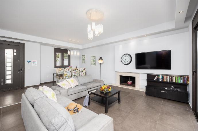 Open-plan living room with sofas, dining area, kitchen, ornamental fireplace, A/C, WiFi internet, satellite TV, and sea views . - Villa Tsampikos . (Galleria fotografica) }}