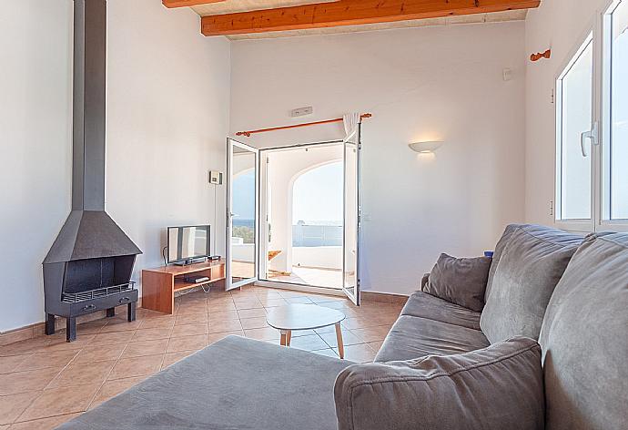 Living room with sofas, dining area, ornamental fireplace, WiFi internet, satellite TV, DVD player, and terrace access with sea views . - Villa Mar . (Photo Gallery) }}