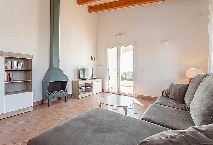 Living room with sofa, dining area, ornamental fireplace, WiFi internet, satellite TV, DVD player, and terrace access with sea views . - Villa Concha . (Galería de imágenes) }}