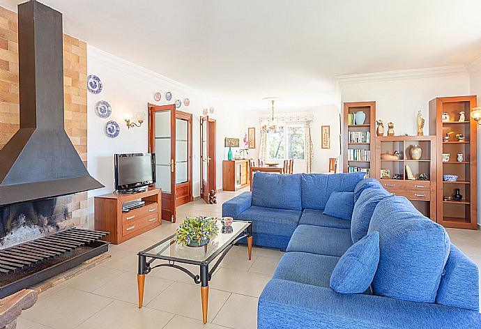 Living room with sofas, dining area, ornamental fireplace, WiFi internet, satellite TV, DVD player, and balcony access . - Villa Luisa . (Photo Gallery) }}