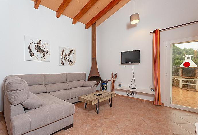 Living room with sofas, dining area, ornamental fireplace, WiFi internet, satellite TV, DVD player, and terrace access . - Villa Casa Xaloc . (Photo Gallery) }}