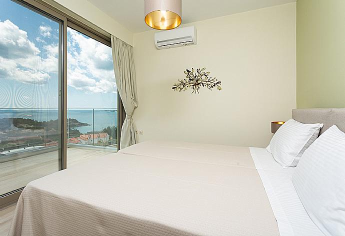 Twin bedroom with en suite bathroom, A/C, and balcony access with sea views . - Villa Lassi Illios . (Fotogalerie) }}