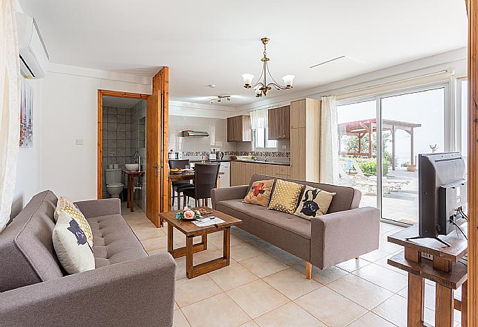 Open-plan living room with sofas, dining area, kitchen, A/C, WIFi internet, satellite TV, and sea views . - Villa Paradiso Sunset . (Fotogalerie) }}