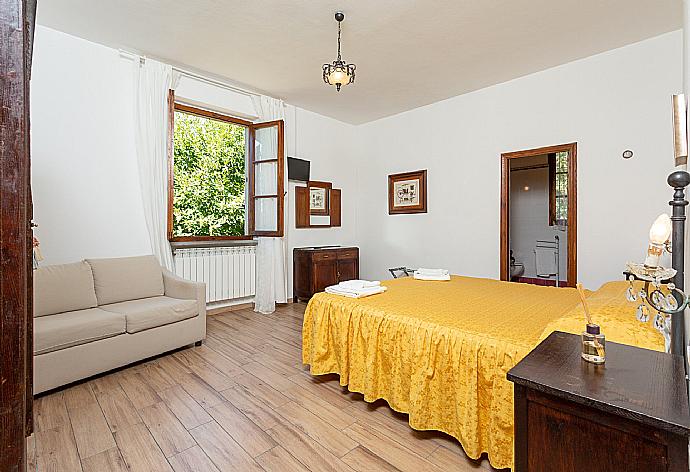 Double bedroom with en suite bathroom and sofa . - Villa Casa al Sole . (Photo Gallery) }}