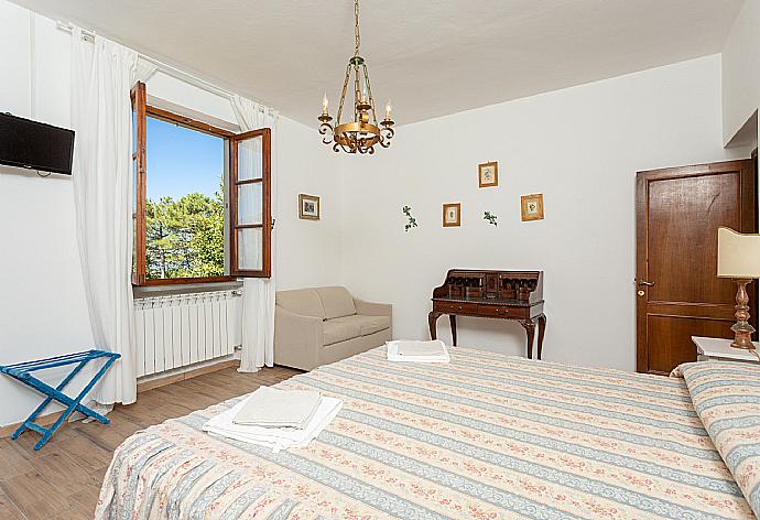 Double bedroom with en suite bathroom, sofa, and TV . - Villa Casa al Sole . (Galleria fotografica) }}