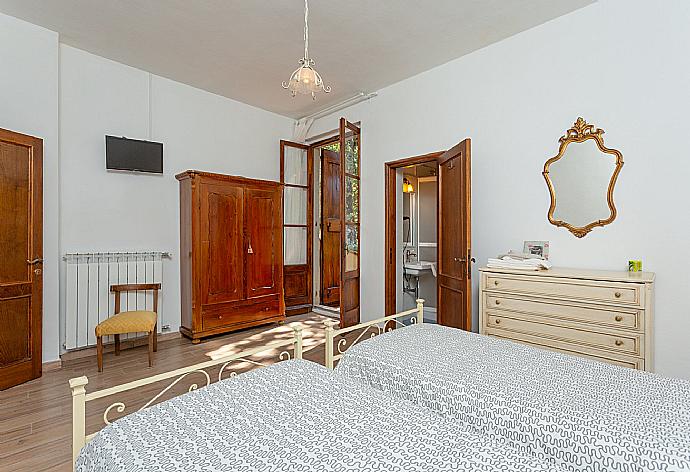 Twin bedroom with en suite bathroom, TV, and balcony access . - Villa Casa al Sole . (Галерея фотографий) }}