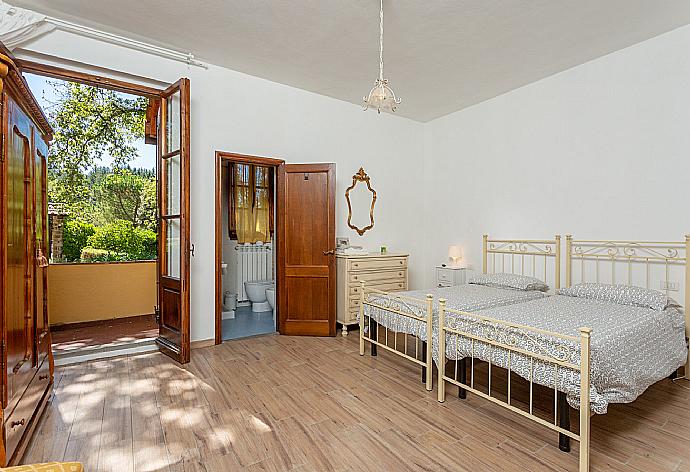 Twin bedroom with en suite bathroom, TV, and balcony access . - Villa Casa al Sole . (Photo Gallery) }}