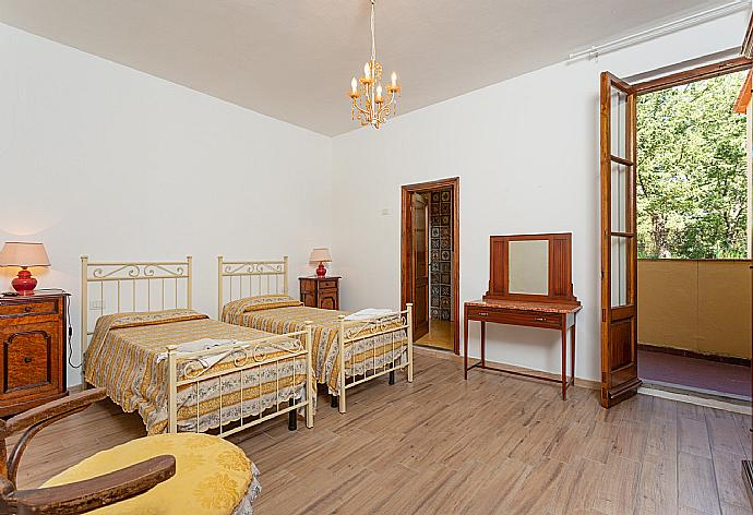 Twin bedroom with en suite bathroom, TV, and balcony access . - Villa Casa al Sole . (Photo Gallery) }}