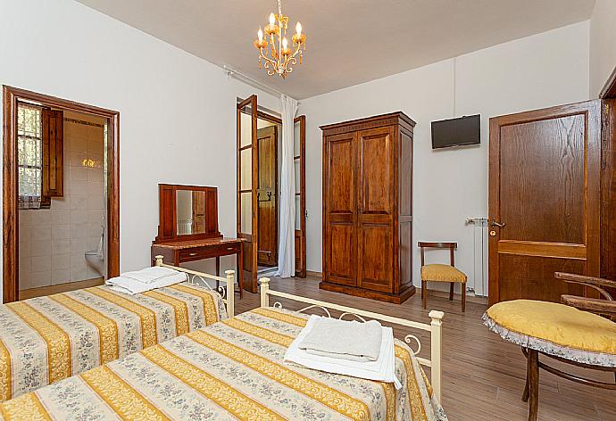 Twin bedroom with en suite bathroom, TV, and balcony access . - Villa Casa al Sole . (Fotogalerie) }}