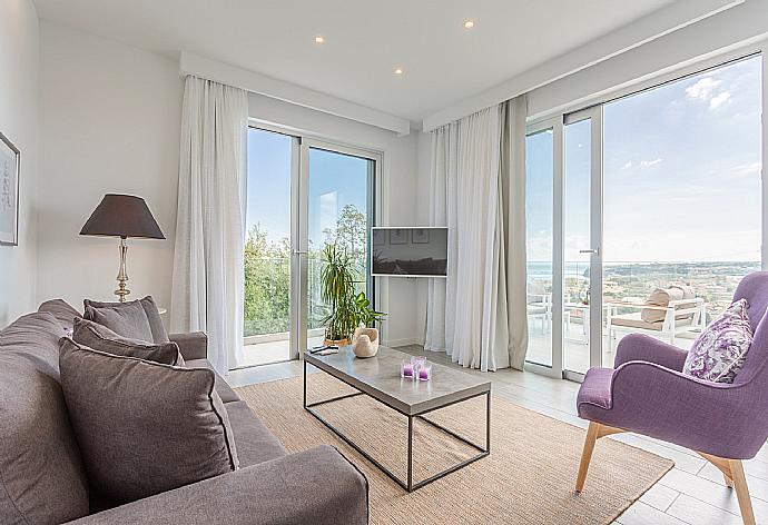 Open-plan living room with sofas, dining area, kitchen, A/C, WiFi internet, satellite TV, and terrace access with sea views . - Apartment Casalma Thio . (Galerie de photos) }}