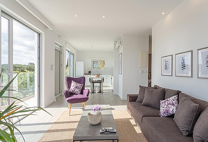 Open-plan living room with sofas, dining area, kitchen, A/C, WiFi internet, satellite TV, and terrace access with sea views . - Apartment Casalma Thio . (Fotogalerie) }}