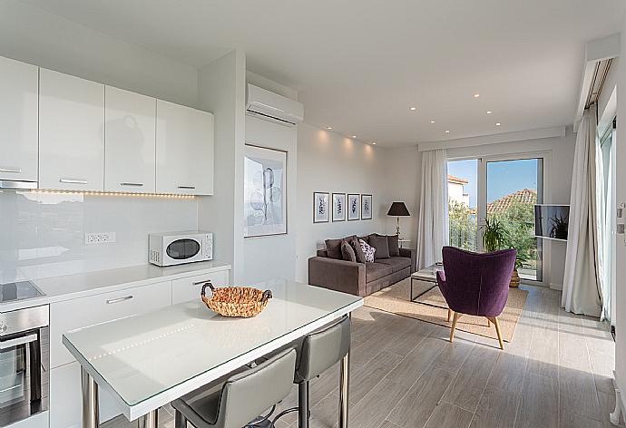 Open-plan living room with sofas, dining area, equipped kitchen, A/C, WiFi internet, satellite TV, and terrace access with sea views . - Apartment Casalma Thio . (Fotogalerie) }}