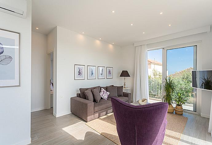 Open-plan living room with sofas, dining area, kitchen, A/C, WiFi internet, satellite TV, and terrace access with sea views . - Apartment Casalma Thio . (Galleria fotografica) }}