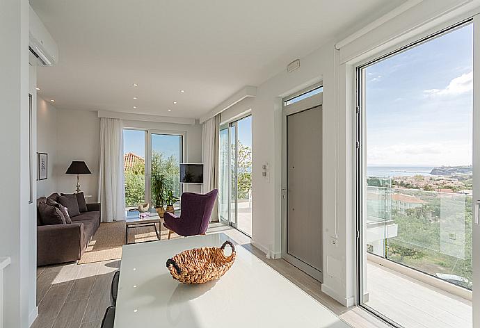 Open-plan living room with sofas, dining area, kitchen, A/C, WiFi internet, satellite TV, and terrace access with sea views . - Apartment Casalma Thio . (Galleria fotografica) }}