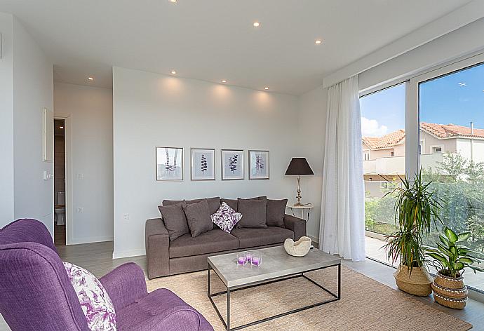 Open-plan living room with sofas, dining area, kitchen, A/C, WiFi internet, satellite TV, and terrace access with sea views . - Apartment Casalma Thio . (Galleria fotografica) }}