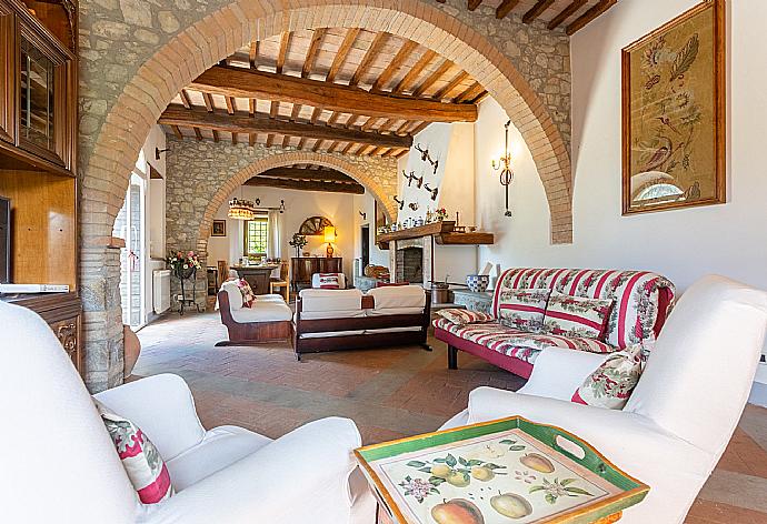 Living room on ground floor with sofas, dining area, ornamental fireplace, WiFi internet, satellite TV, and terrace access . - Villa Il Giulione . (Fotogalerie) }}