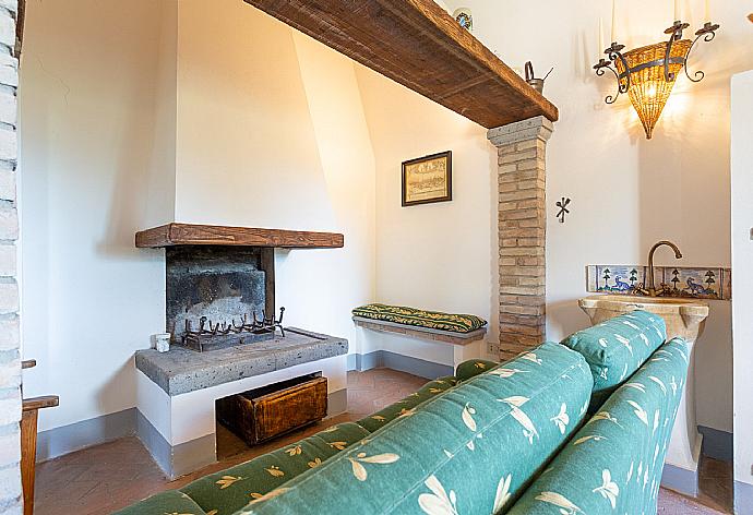 Living room on first floor with sofas and ornamental fireplace . - Villa Il Giulione . (Fotogalerie) }}