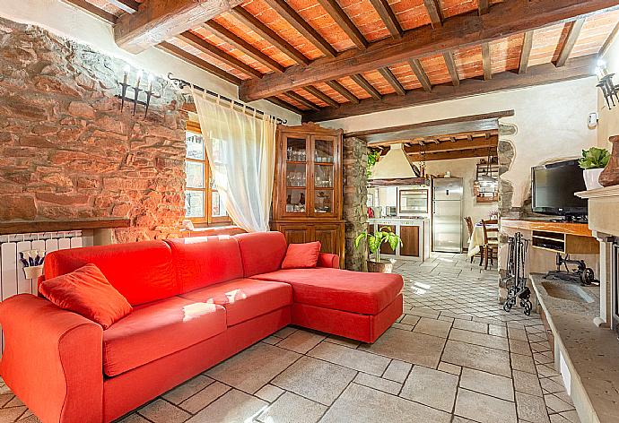 Open-plan living room with sofas, dining area, kitchen, ornamental fireplace, WiFi internet, satellite TV, and garden access . - Villa Casale Le Selve . (Fotogalerie) }}