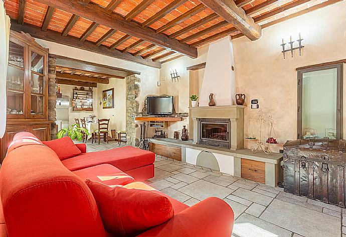 Open-plan living room with sofas, dining area, kitchen, ornamental fireplace, WiFi internet, satellite TV, and garden access . - Villa Casale Le Selve . (Galleria fotografica) }}