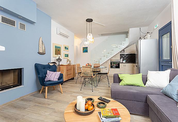 Open-plan living room with sofas, dining area, kitchen, ornamental fireplace, A/C, WiFi internet, satellite TV, DVD player, and pool terrace access . - Villa Amarandos . (Galleria fotografica) }}