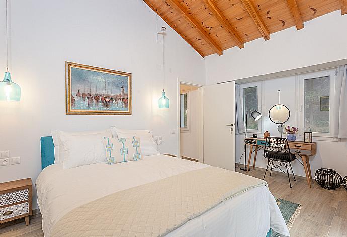 Double bedroom on first floor with A/C, TV, and balcony access . - Villa Amarandos . (Galería de imágenes) }}