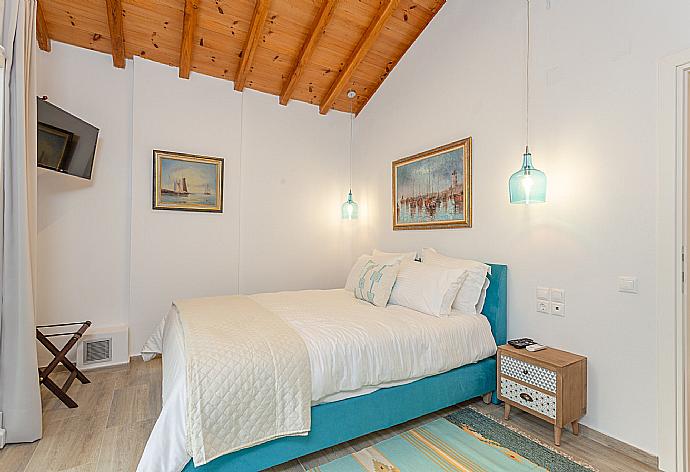 Double bedroom on first floor with A/C, TV, and balcony access . - Villa Amarandos . (Fotogalerie) }}