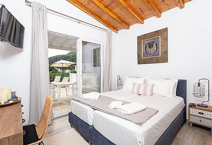 Twin bedroom on ground floor with A/C, TV, and pool terrace access . - Villa Amarandos . (Galerie de photos) }}