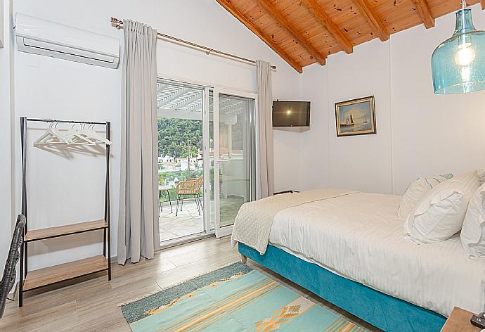 Double bedroom on first floor with A/C, TV, and balcony access . - Villa Amarandos . (Fotogalerie) }}