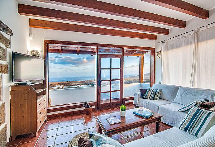 Open-plan living room with sofas, dining area, kitchen, ornamental fireplace, WiFi internet, Satellite TV, and sea views . - Villa Vista Mar . (Fotogalerie) }}