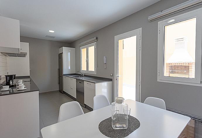 Kitchen with dining area and terrace access . - Villa Mariposas Uno . (Galerie de photos) }}