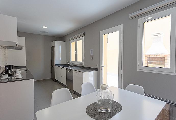 Kitchen with dining area and terrace access . - Villa Mariposas Tres . (Galleria fotografica) }}