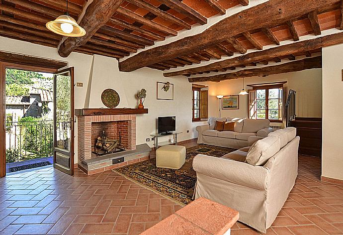 Living room with fireplace, TV and terrace access . - Villa Casale di Rosa . (Galleria fotografica) }}