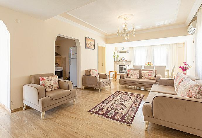 Open-plan living room with sofas, dining area, kitchen, ornamental fireplace, A/C, WiFi internet, satellite TV, and DVD player . - Villa Atlantis . (Fotogalerie) }}