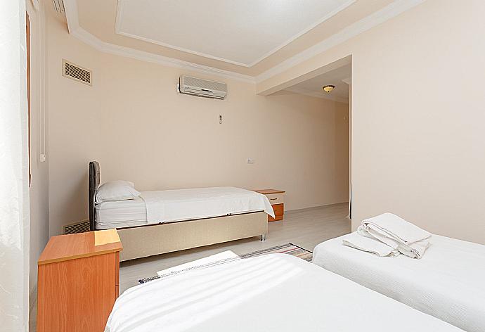 Bedroom with three single beds, en suite bathroom, and A/C . - Villa Atlantis . (Photo Gallery) }}